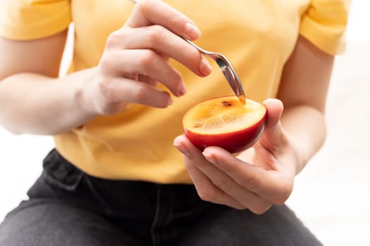 Person, Female Eating Fresh Tamarillo, Fresh Tropical Exotic Fruit With Spoon. Egg-shaped Edible Fruit Known As Tree Tomato, Plant Family Solanaceae, Solanum Betaceum. Closeup. Horizontal Plane.