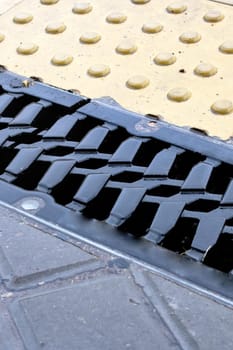 Rain grate on the sidewalk in the rain close up