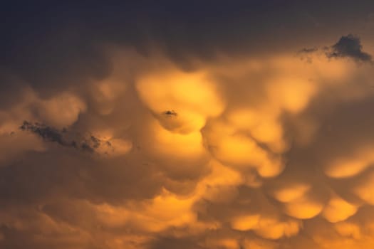 Spectacular yellow clouds in evening sky with weather glow at sunset, Germany