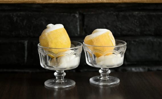 Ice cream sorbet in lemon and glass on black background