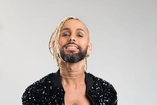 Confident black gay man with make up smiling isolated on white background, dressed black jacket with sequins. Exudes sense of pride and individuality. Diversity power of personal style