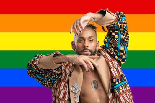 Portrait Trendy black latin gay man in fashionable clothes dancing isolated LGBT flag rainbow colors background studio portrait People fashion lgbtq concept.