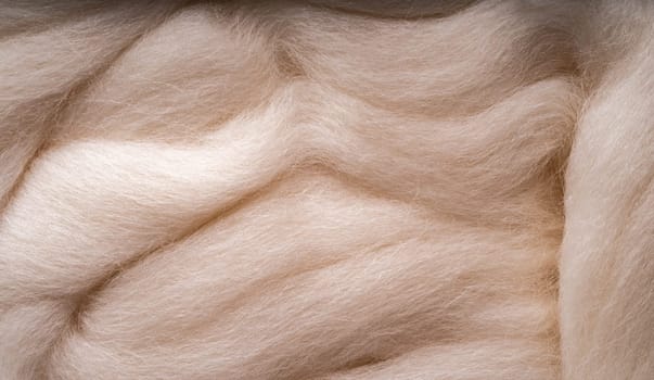 White merino wool for felting as background. Merino wool for felting and needlework, hobby. The stripes of red yarn folded in abstract order.