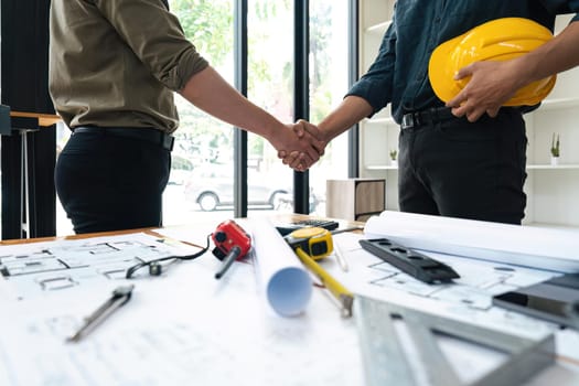 Engineer and contractor shaking hands success of the project work together.