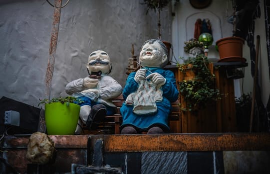 Zell,germany,16-06-2023:images of an elderly couple of which the wife is knitting and the husband watches quietly while sitting on a bench