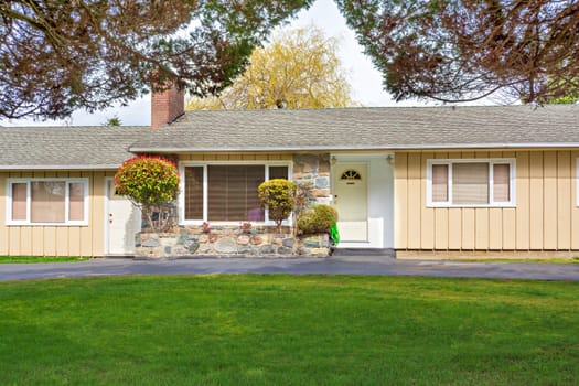 Modest residential duplex house in Canada with green lawn in front.