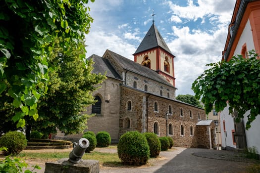 the church with its tower and a cannon in front in Erpel, Rhineland Palatinate, Germany