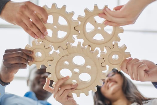 Hand holding wooden gear by businesspeople. Generative AI.