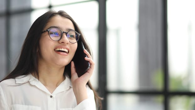 Portrait of young business woman with glasses ofand talking on mobile phone