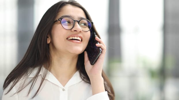 Portrait of young business woman with glasses ofand talking on mobile phone