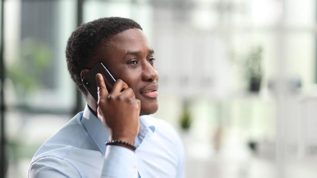 Portrait african american businessman in office with mobile phone speaking talking indoor