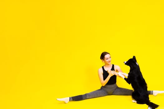 Excited girl dancing with border collie. Studio portrait lady looking at a dog with surprised smile.