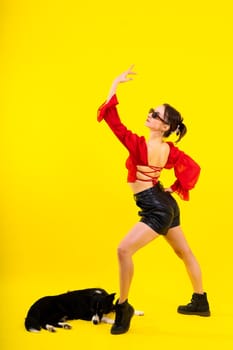 Excited girl dancing with border collie. Studio portrait lady looking at a dog with surprised smile.