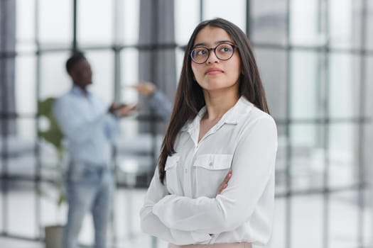 a girl stands in a modern office and looks at the camera