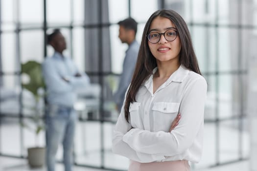 a girl stands in a modern office and looks at the camera