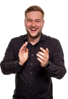 Thrilled excited and over-emotive attractive happy guy smiling broadly gasping and screaming from joy and happiness gesturing with palms clapping hands from surprise and rejoice. Studio portrait on white background