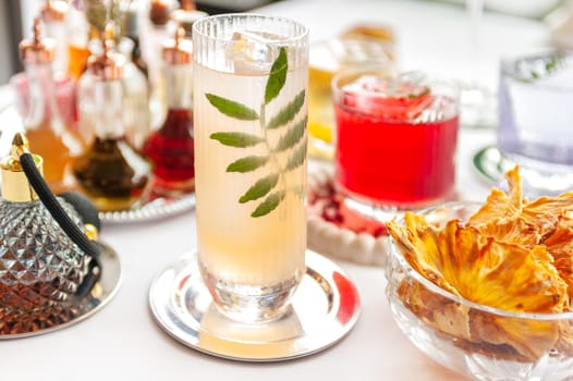 Five colorful summer cocktails in glasses on white table. Assortment of fresh summer drinks. Orange and red sangria cocktails, orange punch cocktail, margarita cocktail, tropical mule.