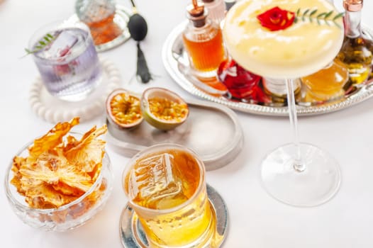 Five colorful summer cocktails in glasses on white table. Assortment of fresh summer drinks. Orange and red sangria cocktails, orange punch cocktail, margarita cocktail, tropical mule.