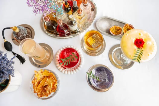 Five colorful summer cocktails in glasses on white table. Assortment of fresh summer drinks. Orange and red sangria cocktails, orange punch cocktail, margarita cocktail, tropical mule.