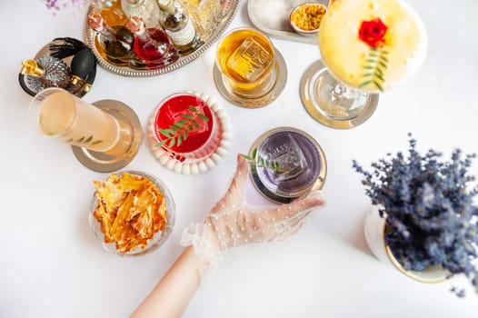 Five colorful summer cocktails in glasses on white table. Assortment of fresh summer drinks. Orange and red sangria cocktails, orange punch cocktail, margarita cocktail, tropical mule.