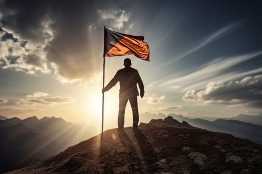 An inspiring image of a man standing atop a mountain peak, proudly holding a flag as a symbol of accomplishment.