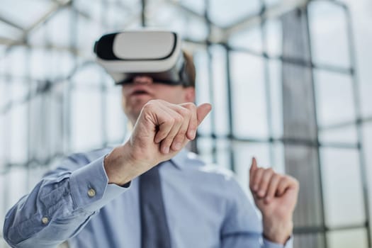 young man testing VR glasses or goggles sitting in the office room