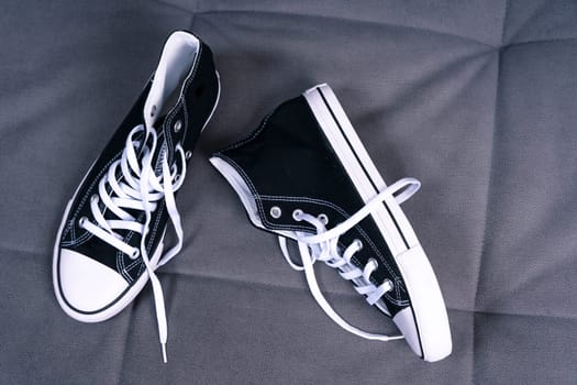 new youth sneakers with lacing lie on the home sofa. Trendy fashionable casual concept. High quality photo