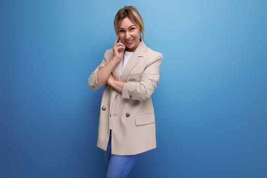 portrait of positive smiling business woman in jacket in studio with copy space.