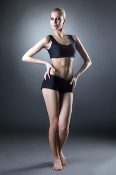 Studio shot of comely sporty woman posing at camera