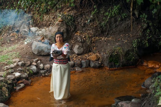 Spiritual ceremony in a sacred place in the Amazon of Ecuador. woman inside volcanic water performing a ritual. High quality photo