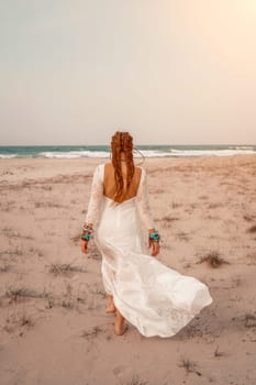 woman sea white dress. Model in boho style in a white long dress and silver jewelry on the beach. Her hair is braided, and there are many bracelets on her arms