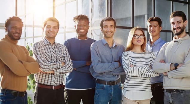 a group of business people of six people standing in the office looking at the camera in casual clothes