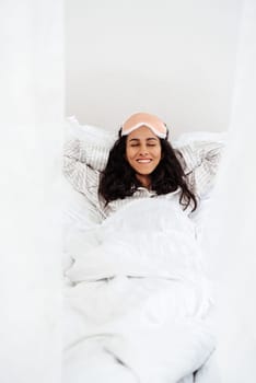 Woman is Arab in appearance and can finally sleep on her day off. The girl is in no hurry to wake up and enjoy the long morning. Girl put her hands behind her head and is ready for relaxation