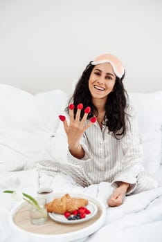 Woman waking up to breakfast in bed - surprised and smiling. Fresh beautiful young woman with breakfast tray. Isolated on white background.