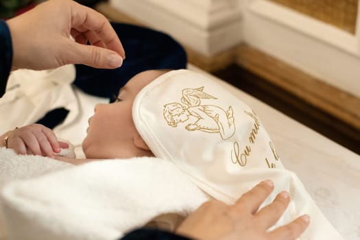 Godmother wraps baby in towel after christening