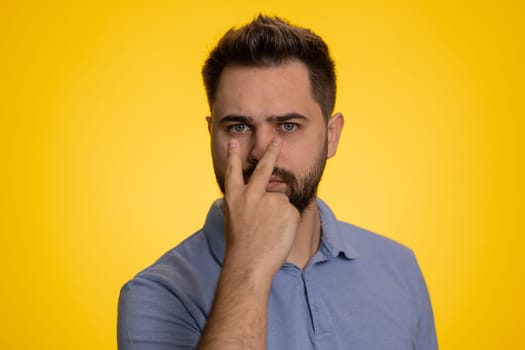 I am watching you. Young confident caucasian man pointing at his eyes and camera, show I am watching you gesture, spying on someone. Handsome bearded guy isolated alone on yellow studio background