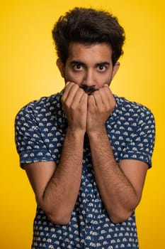 Stressed depressed indian man terrified about danger problems, suffering phobia, anxiety disorder, expresses fear, waving no, insecure, stress, panic. Hindu guy isolated on yellow studio background