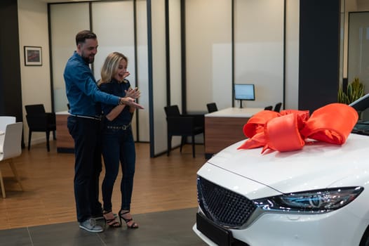 A bearded man makes a gift to his beloved wife in the form of a new white car