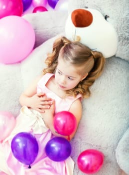 Tired girl posing lying on big teddy bear, close-up