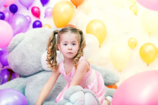Image of funny little girl playing in studio with balloons