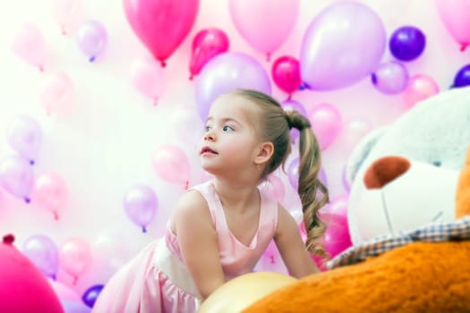 Adorable little lady posing on balloons backdrop