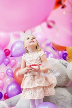 Lovely little girl playing in game room of balloons
