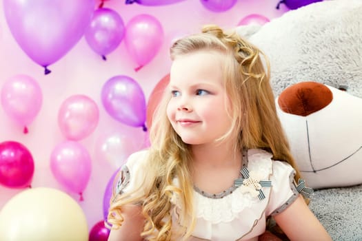 Image of smiling pretty blonde girl posing in playroom