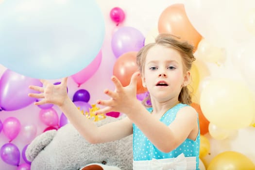 Image of funny little girl plays with balloon in studio