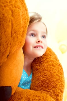 Portrait of cute little girl in arms of teddy bear