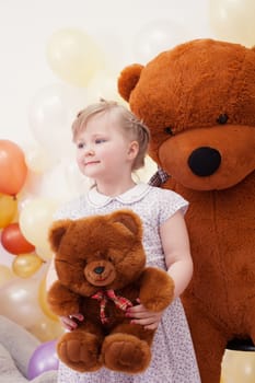 Image of funny blonde girl posing with teddy bears