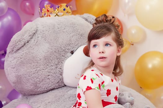 Dreamy little lady posing on backdrop of teddy bear