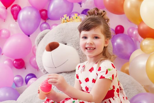 Studio shot of joyful little girl posing in playroom