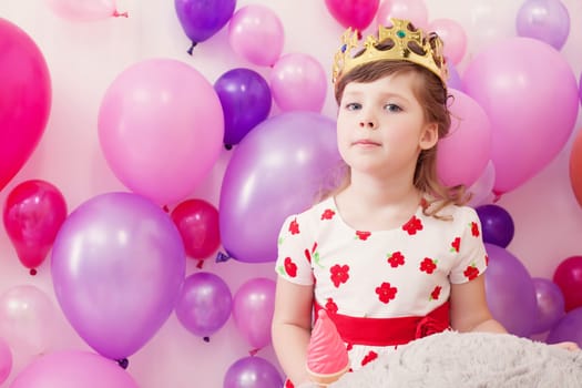 Portrait of funny little girl posing in toy crown