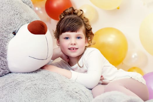 Adorable little girl posing lying on teddy bear